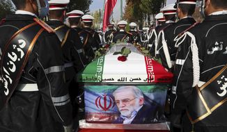 In this photo released by the official website of the Iranian Defense Ministry, military personnel stand near the flag-draped coffin of Mohsen Fakhrizadeh, a scientist who was killed on Friday, during a funeral ceremony in Tehran, Iran, Monday, Nov. 30, 2020. Fakhrizadeh founded Iran&#39;s military nuclear program two decades ago, and the Islamic Republic&#39;s defense minister vowed to continue the man&#39;s work &quot;with more speed and more power.&quot; (Iranian Defense Ministry via AP)
