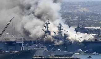 FILE - In this July 12, 2020, file photo, smoke rises from the USS Bonhomme Richard at Naval Base San Diego in San Diego, after an explosion and fire onboard the ship at Naval Base San Diego. The Navy on Monday, Nov. 30, 2020, said that it will decommission the warship docked off San Diego after suspected arson caused extensive damage, making it too expensive to restore. (AP Photo/Denis Poroy, File)