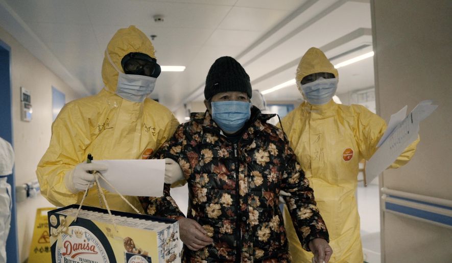 An elderly woman with COVID-19, center, is escorted by two nurses after being admitted to a hospital in Wuhan, China in a scene from the documentary &amp;quot;76 Days.&amp;quot; The film, shot in four Wuhan hospitals, captures a local horror before it became a global nightmare. Given the constraints at the time on footage and information from Wuhan, it&#39;s a rare window into the infancy of the pandemic. (MTV Documentary Films via AP)
