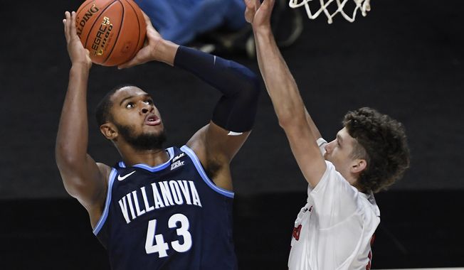 Villanova&#x27;s Eric Dixon, left, shoots over Hartford&#x27;s Hunter Marks in the first half of an NCAA college basketball game, Tuesday, Dec. 1, 2020, in Uncasville, Conn. (AP Photo/Jessica Hill)