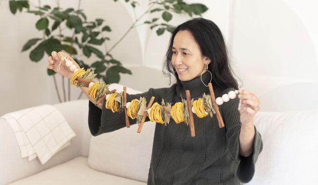 San Francisco Bay-area based Mariam Naficy, shown here, founder of online design marketplace Minted, has been making garlands this year out of various materials, including fragrant dried orange slices. &amp;quot;What I love about these is that they&#x27;re stunning yet easy to make. You can display on a mantle, bookcase, or drape one on your dining table surrounded by tea candles for a simple, aromatic centerpiece.&amp;quot; (Minted via AP)