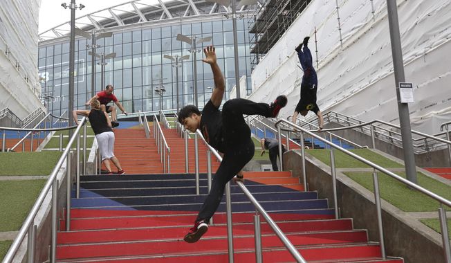 In this Aug. 16, 2018, file photo, participants of the Parkour Generations work on their practice runs outside of Wembley Stadium ahead of the 13th Rendezvous International Parkour Gathering in London. Global organizers of parkour are urging the IOC not to add the street-running sport to the 2024 Paris Olympics at a meeting next week. The Parkour Earth group has for years opposed what it calls a “hostile takeover” of the sport by the Olympic-recognized International Gymnastics Federation. Parkour Earth said Tuesday, Dec. 1, 2020 in an open letter to the International Olympic Committee that the world gymnastic body&#x27;s &amp;quot;encroachment and misappropriation of our sport continues.” (AP Photo/Nishat Ahmed, File)  **FILE**