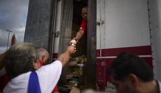 In this Wednesday, Jan. 8, 2020, photo, residents receive aid supplies after suffering the previous day&#39;s magnitude 6.4 quake in Yauco, Puerto Rico. A key U.N. aid agency says needs for humanitarian assistance have ballooned this year because of COVID-19, projecting that a staggering 235 million people — who together would make up the world&#39;s fifth-most populous country — are likely to require such help next year for troubles like the pandemic as well as war, forced migration and the impact of global warming. (AP Photo/Carlos Giusti) **FILE**