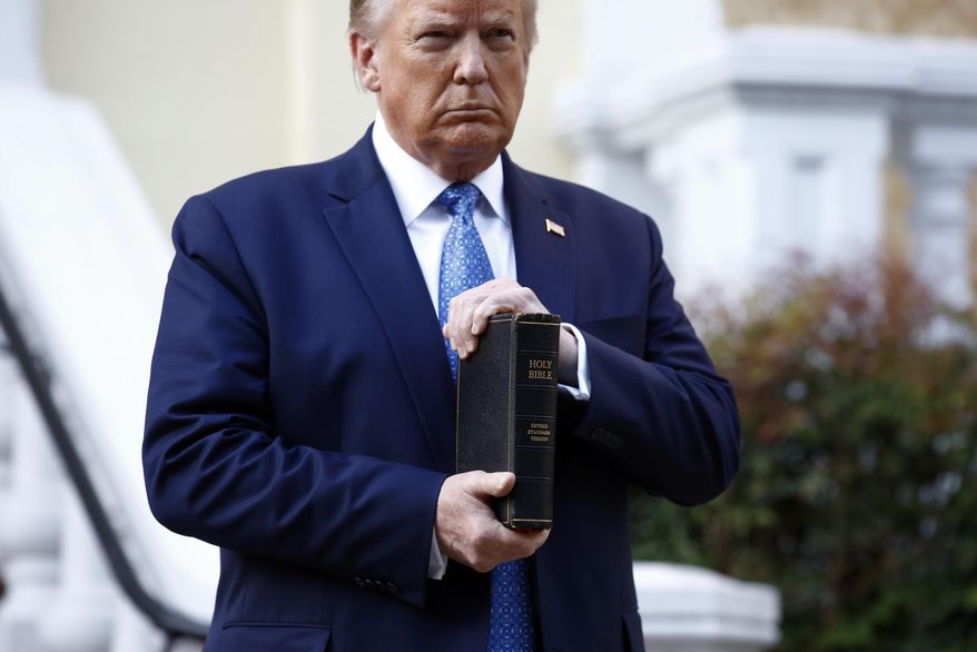 President Donald Trump holds a Bible as he stands outside St. John's Church across Lafayette Park from the White House in Washington on June 1, 2020, after law enforcement officers used tear gas and other riot control tactics to forcefully clear peaceful protesters from the area. (AP Photo/Patrick Semansky)