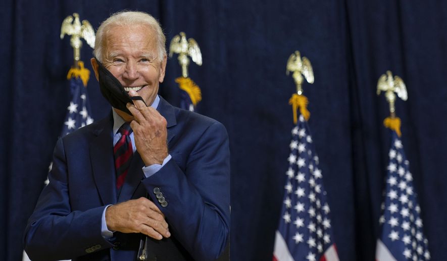 Democratic presidential candidate former Vice President Joe Biden smiles as he puts on his face mask after speaking to media in Wilmington, Del., on Sept. 4, 2020. (AP Photo/Carolyn Kaster)