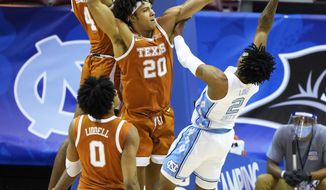 Texas forward Jericho Sims (20) blocks the shot North Carolina guard Caleb Love (2) as Texas forward Gerald Liddell (0) looks for the rebound 104in the first half an NCAA college basketball game for the championship of the Maui Invitational, Wednesday, Dec. 2, 2020, in Asheville, N.C. (AP Photo/Kathy Kmonicek)