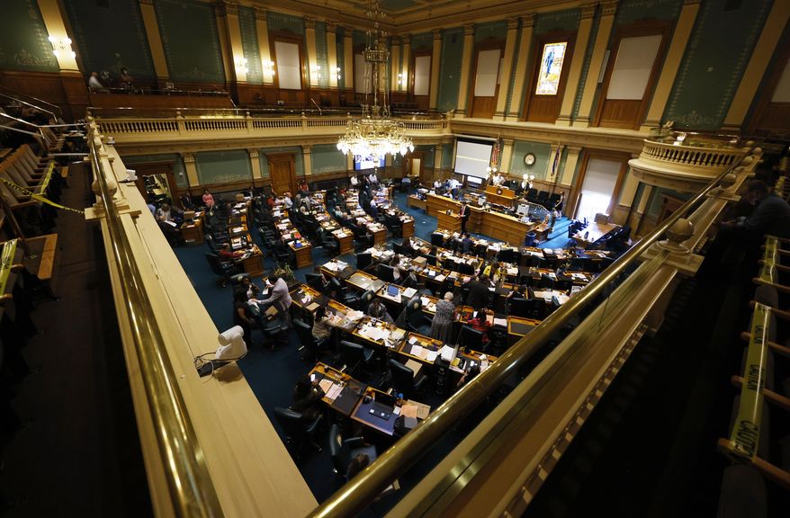 FILE - In this June 15, 2020, file photo, members of the Colorado House of Representatives toil as lawmakers try to wrap up the 2020 session in the State Capitol in Denver. In an effort to keep Colorado residents fed and employed this winter, Colorado's Legislature concluded a special session Wednesday, Dec. 2, by passing bills offering assistance to restaurants and food pantries struggling to keep their doors open during the coronavirus pandemic. This week's session, called by Gov. Jared Polis, also passed bills creating and expanding several grant programs to improve internet access for students, assist childcare providers and aid individuals struggling to pay their utility and housing bills. (AP Photo/David Zalubowski, File)
