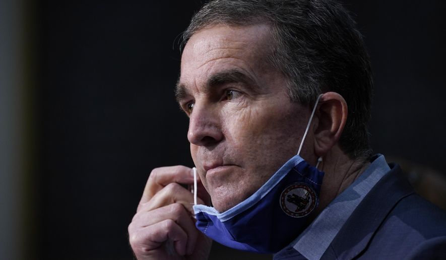 Virginia Gov. Ralph Northam removes his mask to answer a question during a COVID-19 briefing at the Capitol in Richmond, Va, Wednesday Nov 18, 2020. (AP Photo/Steve Helber)