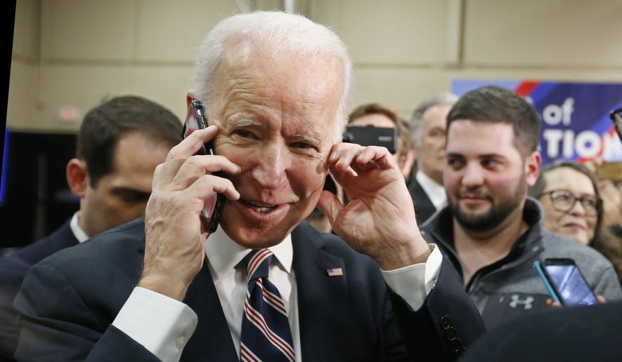 Democratic presidential candidate former Vice President Joe Biden talks on the phone as he greets people during a campaign event Thursday, Jan. 30, 2020, in Waukee, Iowa. (AP Photo/Sue Ogrocki)