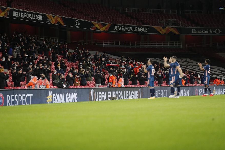 Soccer fans applaud as the teams enter the pitch for the Europa League group B soccer match between Arsenal and Rapid Wien at Emirates stadium in London, England, Thursday, Dec. 3, 2020 . (AP Photo/Frank Augstein)
