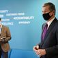 Gov. Roy Cooper, right, is seen during a visit to Gilero in Pittsboro, N.C., Thursday, Dec. 3, 2020. The medical device manufacturer began producing face shields when the pandemic started and also produces swabs for rapid tests in addition to self contained oxygenated negative pressure environments. (AP Photo/Gerry Broome)