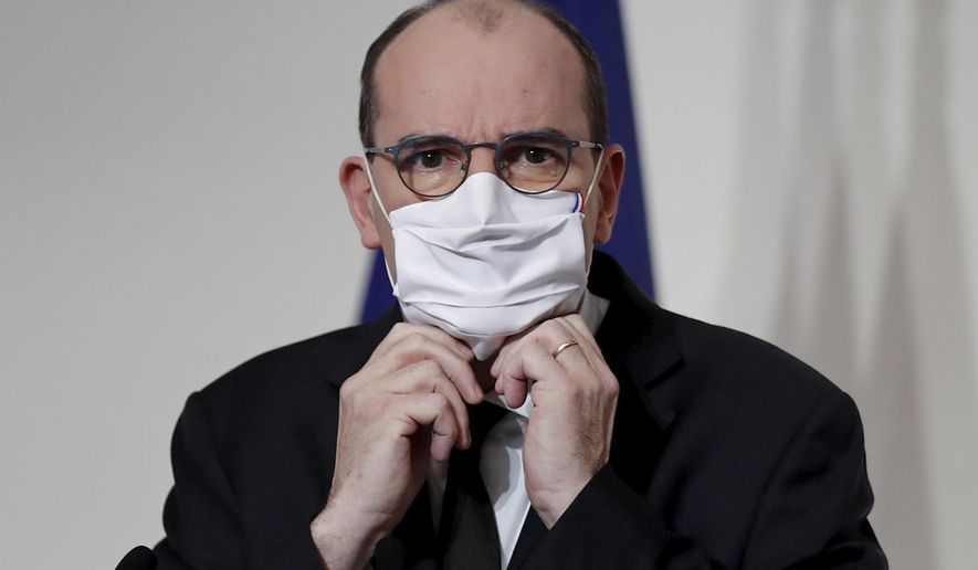 French Prime Minister Jean Castex puts on his protective face mask during a press conference to outline France's strategy for the deployment of future COVID-19 vaccines, in Paris, Thursday Dec. 3, 2020. French Prime Minister Jean Castex said the first doses of COVID-19 vaccines will go to nursing homes residents when they will be available in the country, not before the end of the month.(Benoit Tessier/Pool via AP)