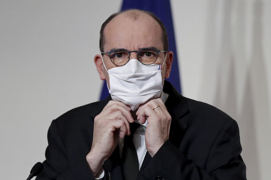 French Prime Minister Jean Castex puts on his protective face mask during a press conference to outline France's strategy for the deployment of future COVID-19 vaccines, in Paris, Thursday Dec. 3, 2020. French Prime Minister Jean Castex said the first doses of COVID-19 vaccines will go to nursing homes residents when they will be available in the country, not before the end of the month.(Benoit Tessier/Pool via AP)