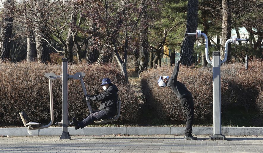 People wearing face masks as a precaution against the coronavirus exercise at a park at a park in Goyang, South Korea, Friday, Dec. 4, 2020. The Korea Disease Control and Prevention Agency said Friday that 600 of the newly confirmed patients were domestically transmitted cases — nearly 80% of them in the densely populous Seoul area, which has been at the center of a recent viral resurgence. (AP Photo/Ahn Young-joon)
