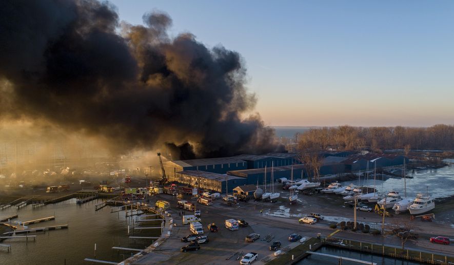 Firefighters battle a large blaze at Toledo Beach Marina in LaSalle, Mich., Friday, Dec. 4, 2020. The number of boats at Toledo Beach Marina could be in the hundreds, said Monroe County emergency manager Mark Hammond. No injuries were reported. (Andy Morrison/Detroit News via AP)