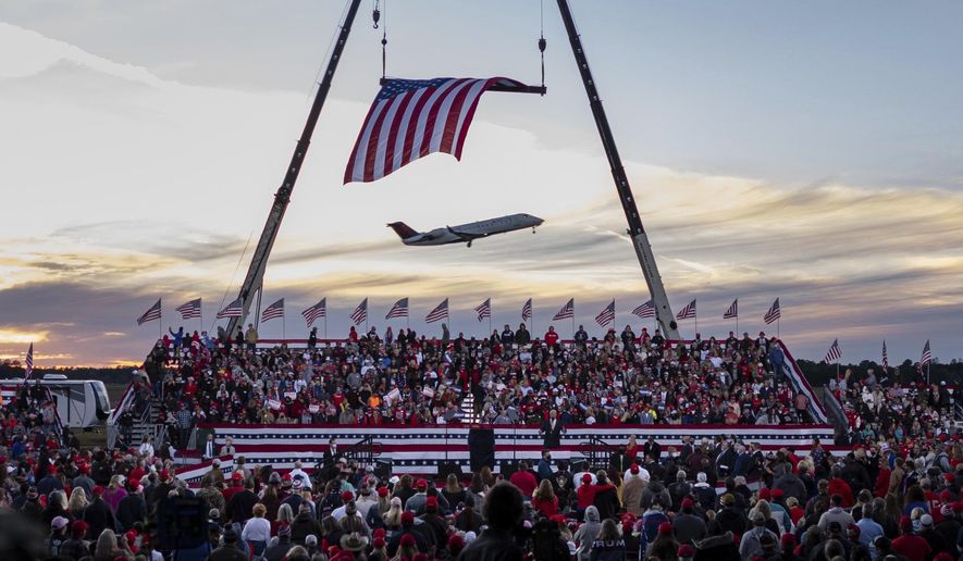 RETRANSMISSION TO CORRECT SPELLING OF PURDUE TO PERDUE - A jet takes off from Valdosta Regional Airport before the start of a rally featuring President Donald Trump for U.S. Senators Kelly Loeffler, R-Ga., and David Perdue, R-Ga., Saturday, Dec. 5, 2020 in Valdosta, Ga. President Trump’s first political rally since losing the election is meant to boost Republican incumbents campaigning in the two Georgia runoffs that will decide which party controls the Senate. (AP Photo/Ben Gray)