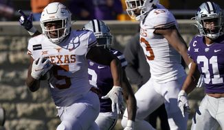 Texas running back Bijan Robinson (5) breaks free for a touchdown during the first half of an NCAA college football game against Kansas State in Manhattan, Kan., Saturday, Dec. 5, 2020. Robinson scored three touchdowns in the game. Texas defeated Kansas State 69-31. (AP Photo/Orlin Wagner)