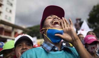 A government supporter shouts in support of parliamentary candidates representing the Great Patriotic Pole party at a closing campaign rally in Caracas, Venezuela, Thursday, Dec. 3, 2020. Polling places in Venezuela open Sunday to elect members of the National Assembly in a vote championed by President Nicolás Maduro but rejected as a fraud by the nation&#39;s most influential opposition politicians. (AP Photo/Ariana Cubillos)