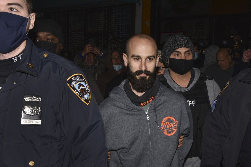 Mac's Public House co-owner Danny Presti is taken away in handcuffs after being arrested by New York City sheriff's deputies, Tuesday, Dec. 1, 2020, in the Staten Island borough of New York. Presti, who was providing indoor service in defiance of coronavirus restrictions, was arrested after a sting in which plainclothes officers went inside and ordered food and beverages. (Steve White via AP)