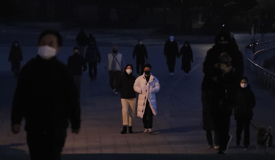 People wearing face masks as a precaution against the coronavirus walk at a park in Goyang, South Korea, Sunday, Dec. 6, 2020. South Korea says it&#39;ll further toughen physical distancing rules as recent restrictions has failed to curb a viral resurgence that threatens the country&#39;s health care system. (AP Photo/Ahn Young-joon)