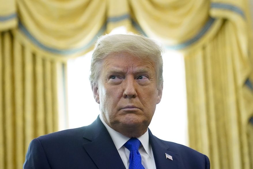 President Donald Trump prepares to award the Presidential Medal of Freedom, the highest civilian honor, to Olympic gold medalist and former University of Iowa wrestling coach Dan Gable in the Oval Office of the White House, Monday, Dec. 7, 2020, in Washington. (AP Photo/Patrick Semansky)