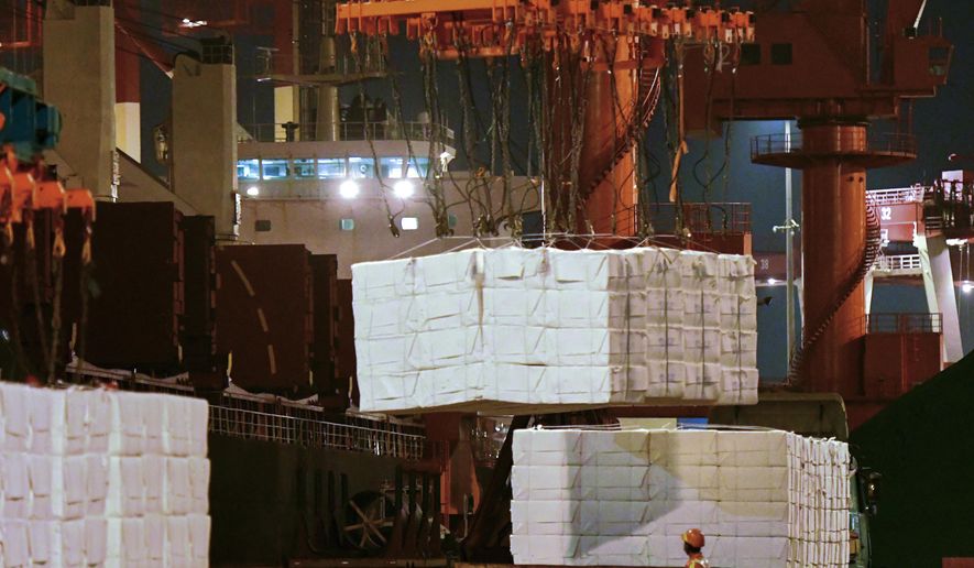 FILE - In this Sept. 25, 2020, file photo, a worker looks at goods being loaded onto a container ship at a dockyard in Qingdao in east China's Shandong province. China’s politically sensitive trade surplus with the U.S. soared to a record $75.4 billion November as exports surged 21.1% over a year earlier, propelled by strong demand from American consumers, customs data showed Monday, Dec. 7, 2020. (Chinatopix va AP, File)