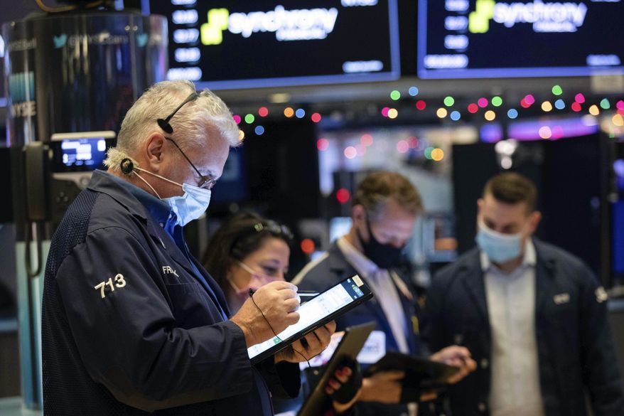 In this photo provided by the New York Stock Exchange, traders work on the floor, Monday, Dec. 7, 2020. U.S. stocks are taking a pause from their big recent rally, and most stocks on Wall Street are edging lower Monday following mixed and mostly muted movements for markets overseas. (Colin Ziemer/New York Stock Exchange via AP)