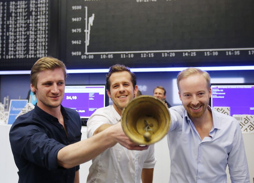 FILE - In this Jan. 10, 2014 file photo, the three CEOs of German online warehouse Zalando, David Schneider, Robert Gentz and Rubin Ritter, from left, ring the bell during the company's initial public offering at the stock market in Frankfurt, Germany. The chief executive of online fashion retailer Zalando Rubin Ritter is stepping down to focus on his family, saying his wife’s career should “take priority” in the coming years. Ritter has been one of three chief executives at Zalando since 2010. (AP Photo/Michael Probst, File)