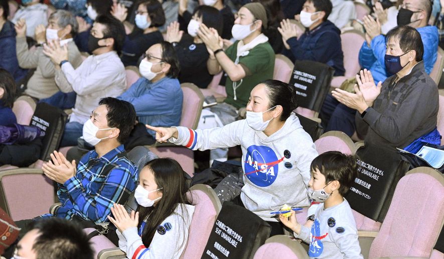 Space enthusiasts cheer as they gather for a public viewing in Sagamihara, near Tokyo Sunday, Dec. 6, 2020. A small capsule from Japan’s Hayabusa2 spacecraft successfully landed in a sparsely populated desert in the Australian Outback on Sunday. (Yu Nakajima/Kyodo News via AP)