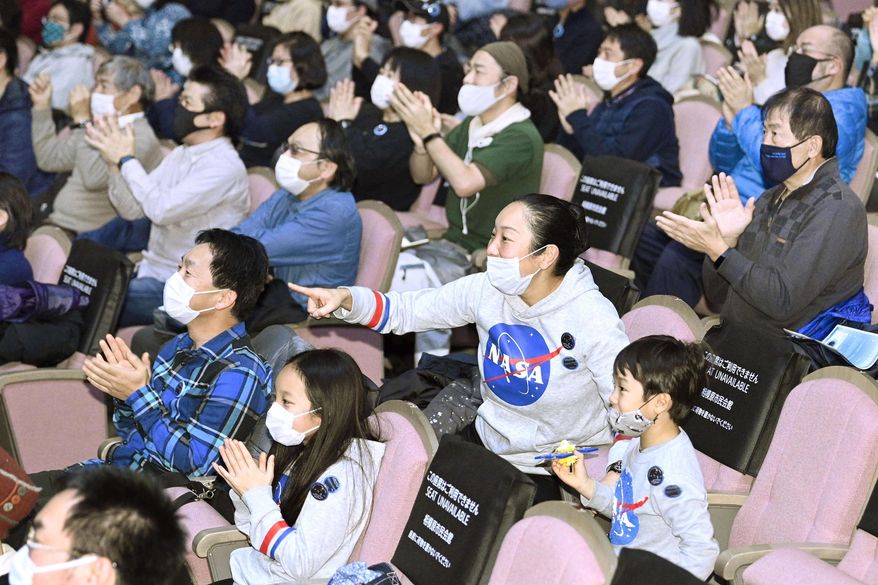 Space enthusiasts cheer as they gather for a public viewing in Sagamihara, near Tokyo Sunday, Dec. 6, 2020. A small capsule from Japan’s Hayabusa2 spacecraft successfully landed in a sparsely populated desert in the Australian Outback on Sunday. (Yu Nakajima/Kyodo News via AP)