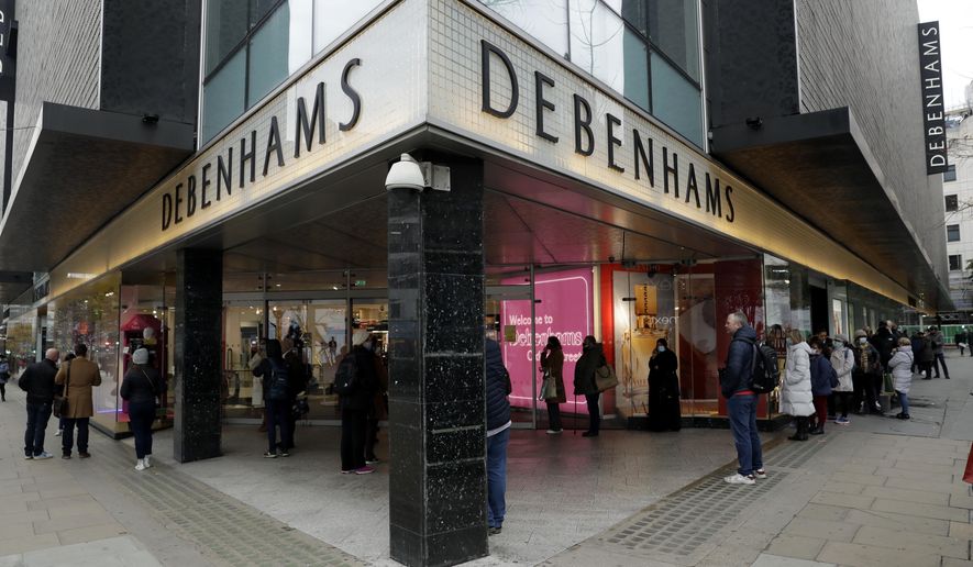 People queue up waiting for the Debenhams department store, which is expected to close down, to open for the day&#39;s trading as non-essential shops are allowed to reopen after England&#39;s second lockdown ended at midnight, on Oxford Street, in London, Wednesday, Dec. 2, 2020. In another dark day for the British retailing industry, Debenhams said Tuesday it will start liquidating its business after a potential buyer of the company pulled out, a move that looks like it will cost 12,000 workers their jobs. (AP Photo/Matt Dunham)