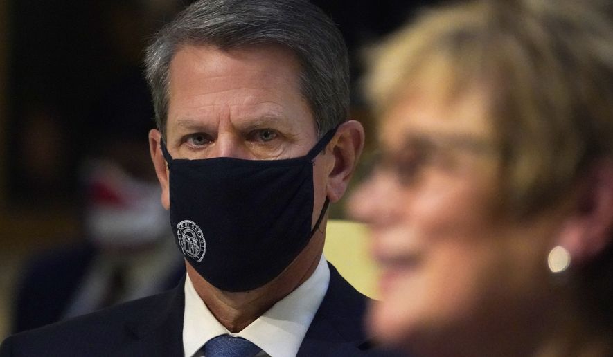 In this file photo, Georgia Gov. Brian Kemp looks on as Commissioner of Department of Health Dr. Kathleen Toomey speaks speaks to reporters during a COVID-19 update in the Capitol Tuesday, Dec. 8, 2020, in Atlanta. (AP Photo/John Bazemore) **FILE**