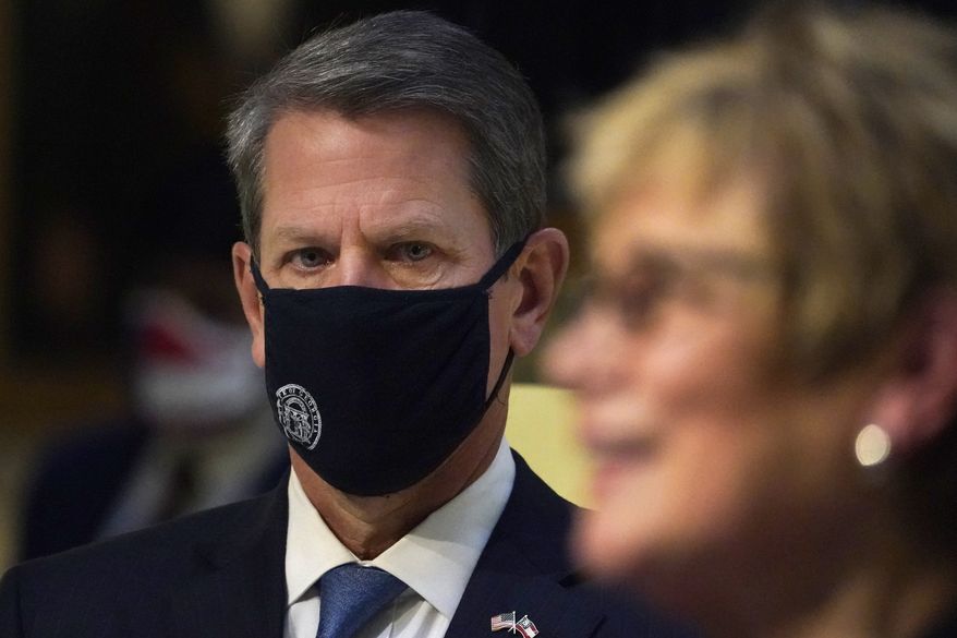In this file photo, Georgia Gov. Brian Kemp looks on as Commissioner of Department of Health Dr. Kathleen Toomey speaks speaks to reporters during a COVID-19 update in the Capitol Tuesday, Dec. 8, 2020, in Atlanta. (AP Photo/John Bazemore) **FILE**