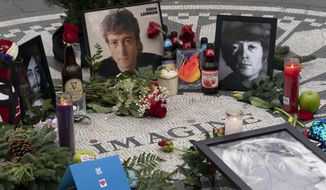 Photos, flowers, and candles have been left at Strawberry Fields in New York&#39;s Central Park to remember John Lennon, Tuesday, Dec. 8, 2020. The rock star and former Beatle was shot to death outside his New York City apartment building by a fan on Dec. 8, 1980. (AP Photo/Mark Lennihan)