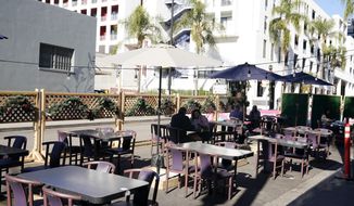 In this Dec. 4, 2020, file photo, empty tables are seen outside of a restaurant set up for outdoor dining in Burbank, Calif. Five California legislative assembly members dined together outdoors Monday, Dec. 8, 2020, despite surging coronavirus case levels that have triggered stay at home orders for much of the state&#39;s population. State rules are silent as to how many households can dine together outdoors at restaurants, but health officials have implored people to limit outside gatherings to no more than three households.(AP Photo/Marcio Jose Sanchez, File)  **FILE**