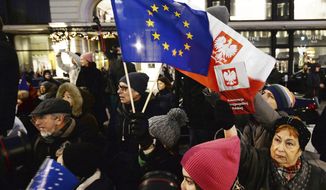 In this  Jan. 11, 2020, file photo, protesters carry an EU flag at an anti-government protest in Warsaw, Poland. Some Poles are afraid that a drawn-out conflict with the EU over the next budget and values could put them on a path toward an eventual departure from the bloc, or &quot;Polexit.&quot; Poland&#39;s conservative government denies that it has ever wanted to leave the 27-member bloc and popular support for EU membership runs very high. But critics fear the combative tone of some Polish leaders could create momentum which could accidentally bring the nation to the exit door. (AP Photo/Czarek Sokolowski, File)