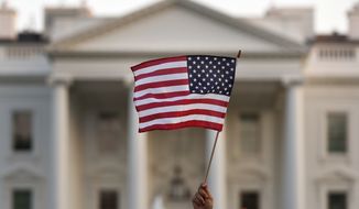FILE - In this Sept. 2017 file photo, a flag is waved during an immigration rally outside the White House, in Washington.  The Trump administration says it&#39;ll allow migrants from six countries to extend their legal U.S. residency under a temporary status for nine months while courts consider its effort to end the program. President Donald Trump has long sought to terminate the program, which allows migrants from countries devastated by war or natural disaster to legally live in the U.S. President-elect Joe Biden has promised “an immediate review&quot; of it and said he’ll pursue legislation for longtime residents to remain and seek U.S. citizenship. The Department of Homeland Security announced the extension Wednesday.  (AP Photo/Carolyn Kaster)