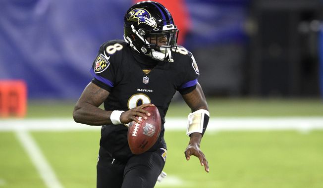 Baltimore Ravens quarterback Lamar Jackson rolls out against the Dallas Cowboys during the first half of an NFL football game, Tuesday, Dec. 8, 2020, in Baltimore. (AP Photo/Nick Wass)