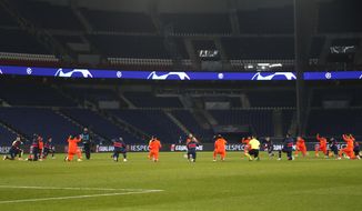 Basaksehir players kneel in support of the Black Lives Matter campaign before the start of the Champions League group H soccer match between Paris Saint Germain and Istanbul Basaksehir at the Parc des Princes stadium in Paris, France, Wednesday, Dec. 9, 2020. The match is resuming on Wednesday with a new refereeing team after players from Paris Saint-Germain and Istanbul Basaksehir left the field on Tuesday evening and didn&#39;t return when the fourth official — Sebastian Coltescu of Romania — was accused of using a racial term to identify Basaksehir assistant coach Pierre Webo before sending him off for his conduct on the sidelines. (AP Photo/Francois Mori)