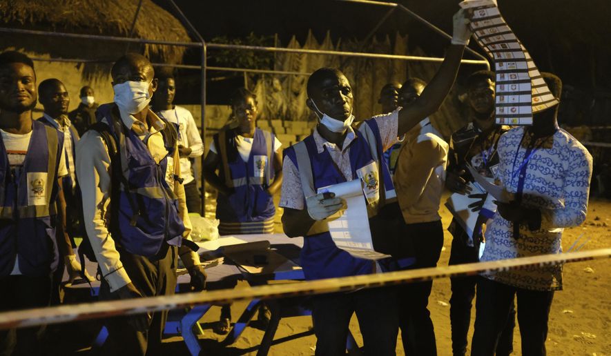 Electoral commission officials count the ballots after polls closed in Accra, Ghana, Monday, Dec. 7, 2020. Voters lined up early in Ghana to cast their ballots in presidential and legislative elections likely to test the West African nation's credentials as one of the most politically stable countries on the continent. (AP Photo/Ofoe Amegavie)