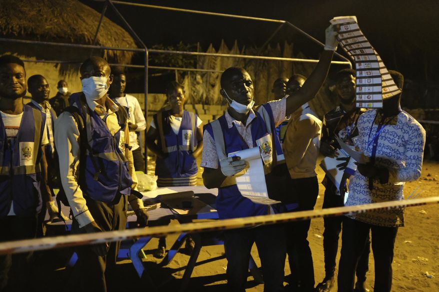 Electoral commission officials count the ballots after polls closed in Accra, Ghana, Monday, Dec. 7, 2020. Voters lined up early in Ghana to cast their ballots in presidential and legislative elections likely to test the West African nation's credentials as one of the most politically stable countries on the continent. (AP Photo/Ofoe Amegavie)