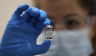A nurse holds a vial of the Pfizer-BioNTech COVID-19 vaccine at Guy&#x27;s Hospital in London, Tuesday, Dec. 8, 2020, as the U.K. health authorities rolled out a national mass vaccination program. (AP Photo/Frank Augstein, Pool)