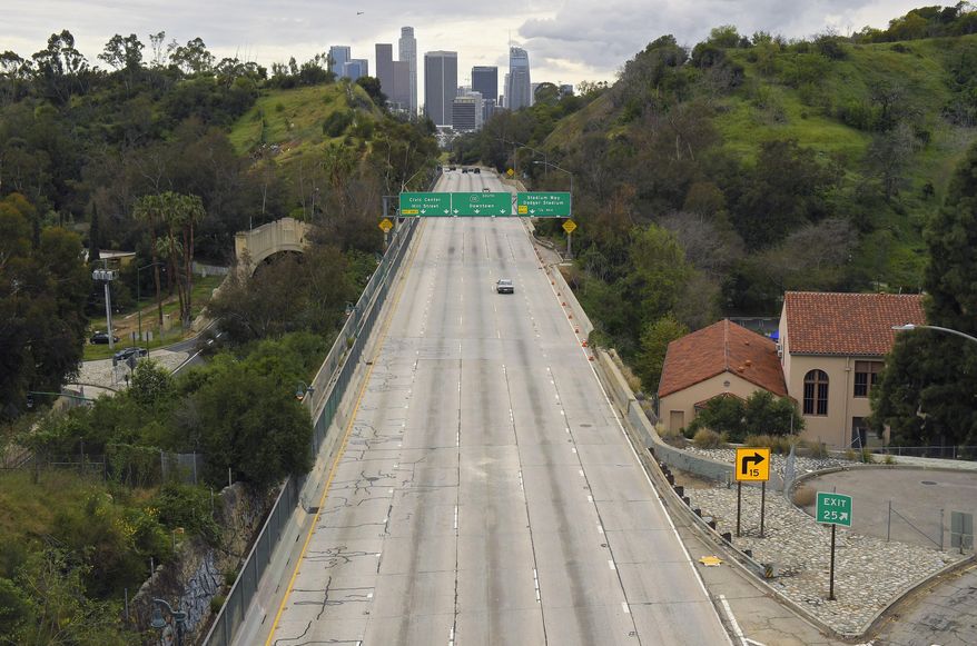 FILE - In this Friday, March 20, 2020 file photo, extremely light traffic moves along the 110 Harbor Freeway toward downtown Los Angeles in the mid-afternoon. Traffic would normally be bumper-to-bumper during this time of day on a Friday. New calculations released on Thursday, Dec. 10, 2020, show the world's carbon dioxide emissions plunged 7% in 2020 because of the pandemic lockdowns. (AP Photo/Mark J. Terrill)