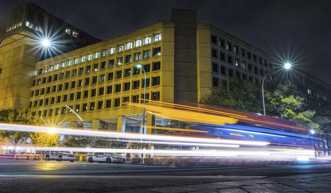 In this Nov. 1, 2017, file photo, traffic along Pennsylvania Avenue in Washington streaks past the Federal Bureau of Investigation headquarters building. Senior lawmakers demanded Tuesday that an inspector general investigate the Biden administration&#x27;s decision to move the FBI&#x27;s headquarters to Maryland, saying the process was &quot;contaminated&quot; by political dealings. (AP Photo/J. David Ake, File)