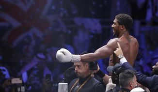 FILE - In this file photo dated Sunday Dec. 8, 2019, Britain&#39;s Anthony Joshua celebrates after beating Andy Ruiz Jr. to win their World Heavyweight Championship contest at the Diriyah Arena, Riyadh, Saudi Arabia.  Joshua was able to end his self-isolation on Wednesday Dec. 9, 2020, after his coronavirus test came back negative ahead of his world heavyweight clash with Kubrat Pulev at Wembley in London on upcoming Saturday Dec. 12, 2020. (AP Photo/Hassan Ammar, FILE)