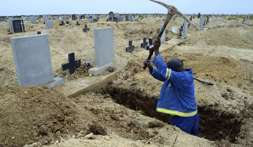 A grave digger prepares graves at the Motherwell Cemetery in Port Elizabeth, South Africa, Friday, Dec. 4, 2020. Health Minister Zweli Mkhize announced on Wednesday, Dec. 9, 2020 that the country is now experiencing a Covid-19 pandemic second wave. (AP Photo/Theo Jeftha)