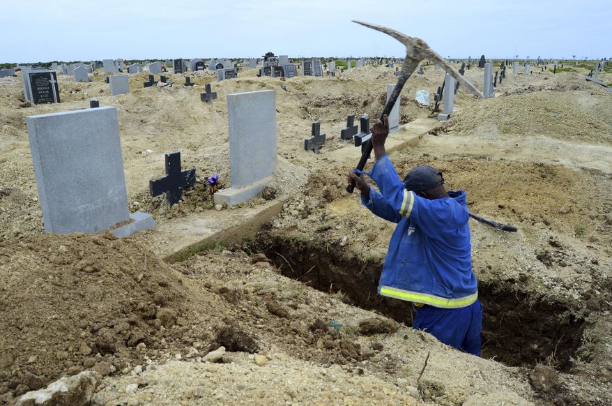 A grave digger prepares graves at the Motherwell Cemetery in Port Elizabeth, South Africa, Friday, Dec. 4, 2020. Health Minister Zweli Mkhize announced on Wednesday, Dec. 9, 2020 that the country is now experiencing a Covid-19 pandemic second wave. (AP Photo/Theo Jeftha)