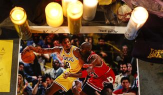 A picture of Kobe Bryant and Michael Jordan is played at a memorial for Bryant in front of Staples Center Jan. 28, 2020, in Los Angeles. Bryant, the 18-time NBA All-Star who won five championships and became one of the greatest basketball players of his generation during a 20-year career with the Los Angeles Lakers, died in a helicopter crash on Jan. 26. (AP Photo/Ringo H.W. Chiu, File) **FILE**