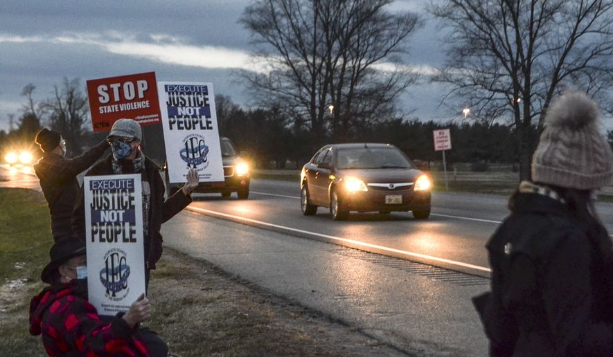Protesters stand across Prairieton Road from the Federal Death Chamber Friday, Dec. 11, 2020 in Terre Haute, Ind. The Trump administration plans to continue its unprecedented series of post-election federal executions Friday by putting to death Alfred Bourgeois who severely abused his 2-year-old daughter for weeks in 2002, then killed her by slamming her head against a truck's windows and dashboard. (Austen Leake/The Tribune-Star via AP) **FILE**