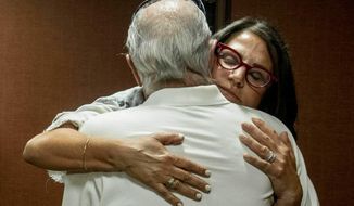 FILE - In this July 11, 2019 file photo, Tanya Gersh, a Montana real estate agent, embraces her father Lloyd Rosenstein following a hearing at the Russell Smith Federal Courthouse in Missoula. Mont. A Montana real estate agent who secured a $14 million judgment against a neo-Nazi website operator for orchestrating an anti-Semitic harassment campaign against her Jewish family is seeking a court order compelling the man to disclose information about his assets and finances. Tanya Gersh&#39;s attorneys said in a court filing Friday, Dec. 11, 2020 that The Daily Stormer founder Andrew Anglin hasn&#39;t paid any portion of the August 2019 judgment and has ignored their requests for information about his current whereabouts, his operation of the website and other assets. (Ben Allen/The Missoulian via AP, File)